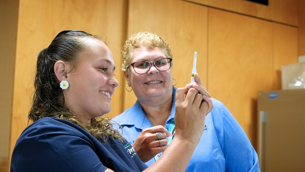 Two nurses looking at needle