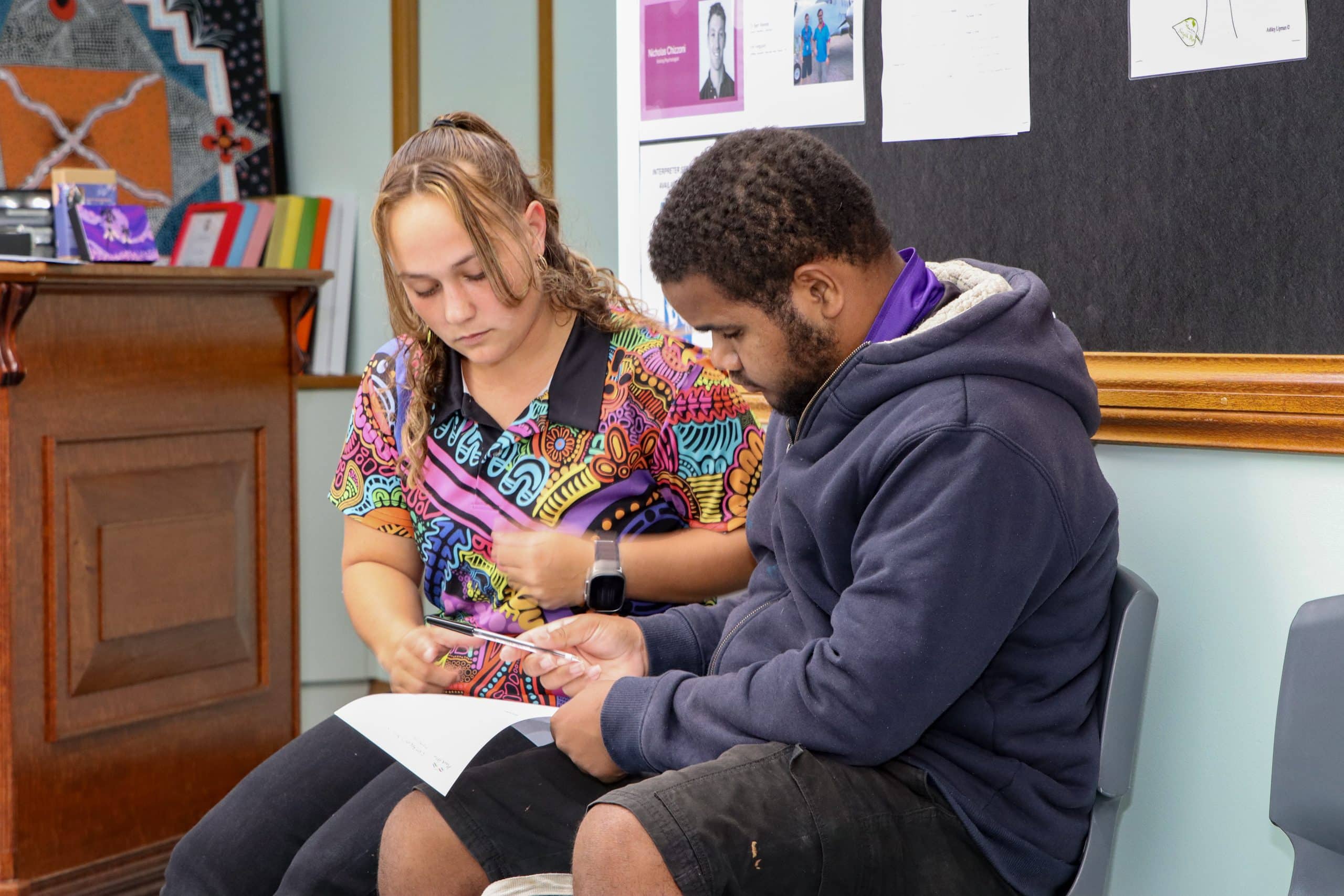 Jayrahni helps a Djarragun College student with paperwork
